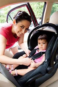 Majka smesta dete u automobil u decije auto sediste